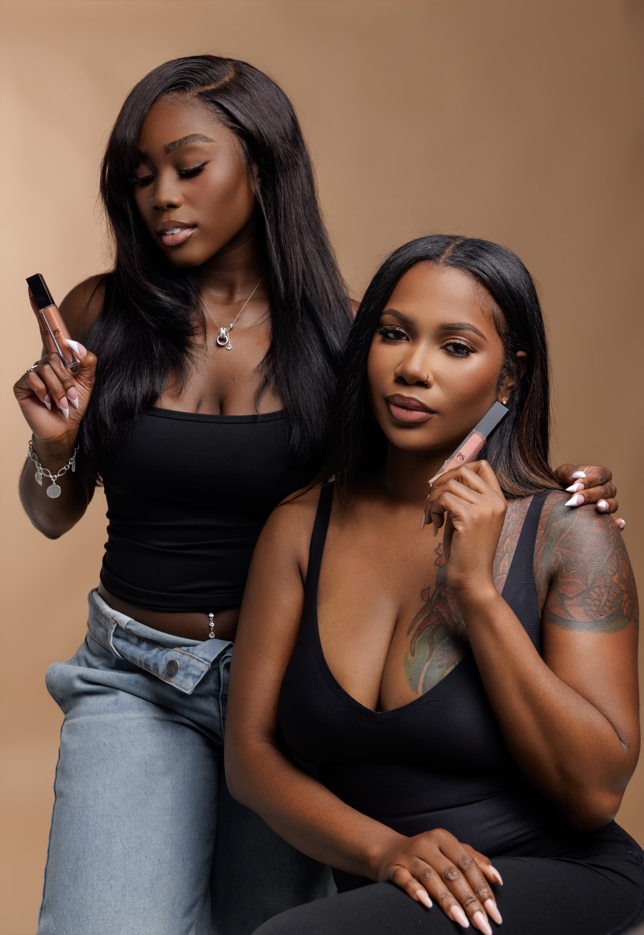 Two models holding PS Beauty lip gloss